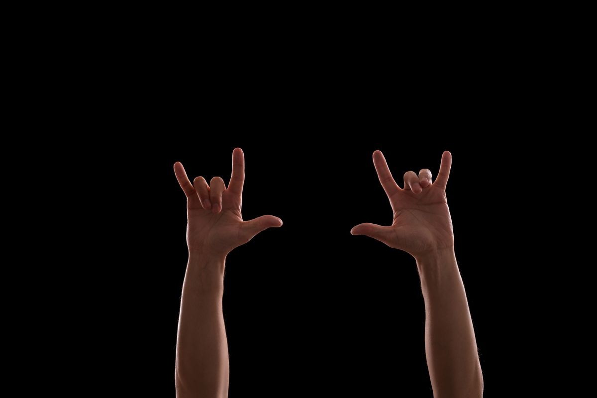 Raised hands in the dark on rock music concert